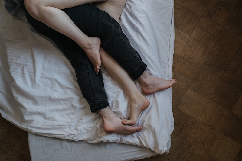 man and woman's legs in bed
