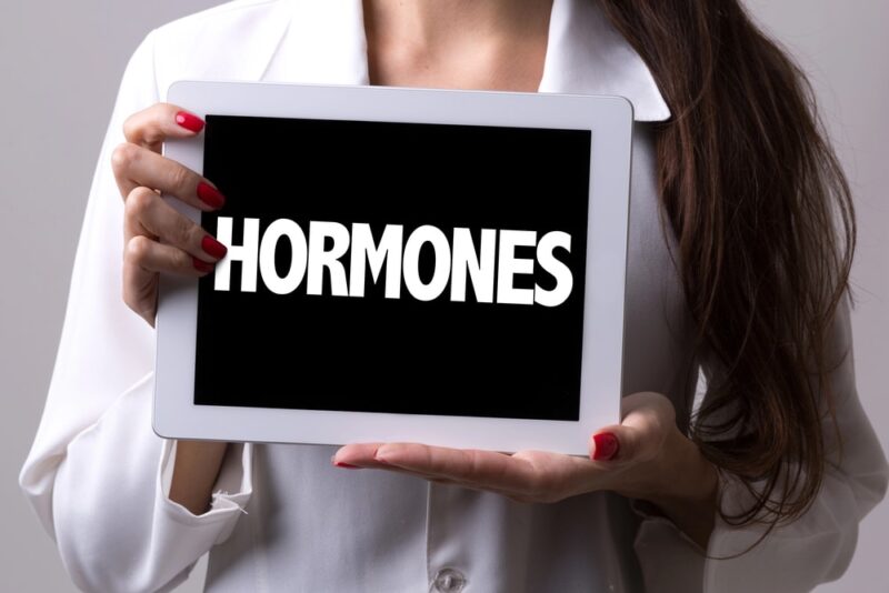 Woman holding sign displaying hormones
