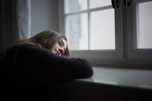 woman leaning against window
